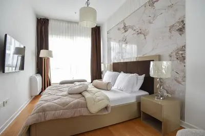 a bedroom with a large bed with a marble wall at Apartment with 2 rooms in Tre canne hotel in Budva