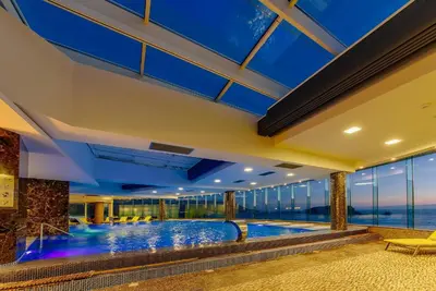 an indoor swimming pool in a building with blue ceilings at Two rooms in Tre canne hotel in Budva