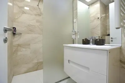 a white bathroom with a sink and a shower at Two rooms in Tre canne hotel in Budva