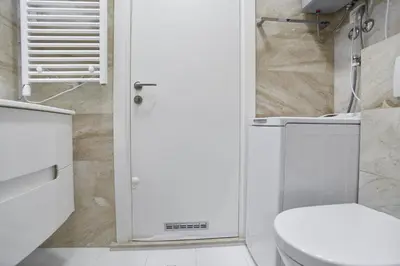 a white bathroom with a toilet and a shower at Two rooms in Tre canne hotel in Budva