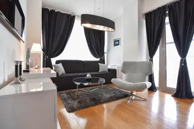 a living room with a couch and a table and a chair at Luxury one bedroom apartment in beachfront apart Hotel in Budva
