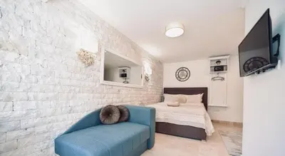 a living room with a blue couch and a bed at OLD TOWN Budva apart 3 with balcony in Budva