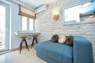 a blue couch in a room with a brick wall at OLD TOWN Budva apart 3 with balcony in Budva