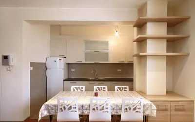a kitchen with a table and chairs and a refrigerator at Apartments Dangubic in Petrovac na Moru