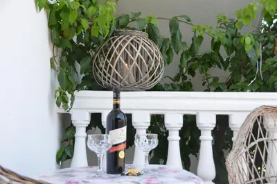 a bottle of wine sitting on a table with two glasses at Apartment Dragovic in Ulcinj