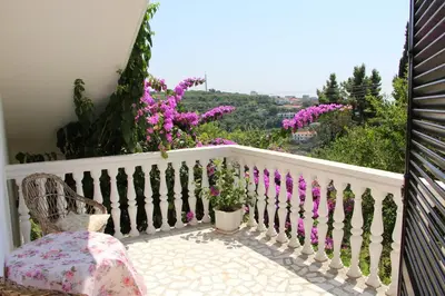 a balcony with a chair and purple flowers at Apartment Dragovic in Ulcinj