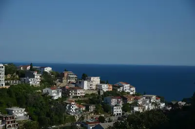 a group of houses on a hill next to the ocean at Apartment Dragovic in Ulcinj