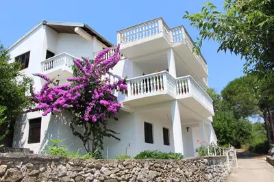a white house with purple flowers in front of it at Apartment Dragovic in Ulcinj