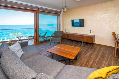 a living room with a couch and a table at Sunset Bay Apartments in Utjeha