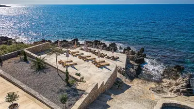 an aerial view of a beach with chairs and the ocean at Sunset Bay Apartments in Utjeha