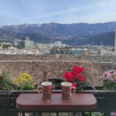 two coffee mugs on a table with flowers on it at Guesthouse Bogdanovic in Budva