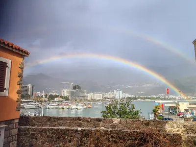 a rainbow over a harbor with boats in the water at Guesthouse Bogdanovic in Budva