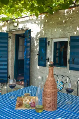 a table with a vase and a plate of food at Holiday Home Neda in Sveti Stefan