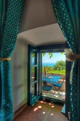 a room with a door open to a patio with a table at Holiday Home Neda in Sveti Stefan