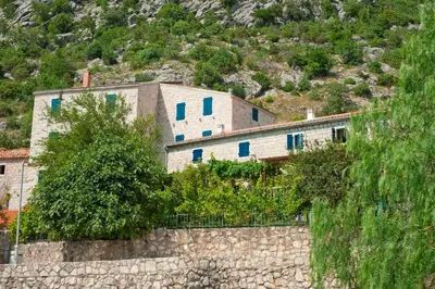 a building on top of a stone wall at Holiday Home Neda in Sveti Stefan