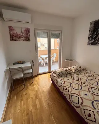 a bedroom with a bed and a desk and a table at Studio 23 in Podgorica