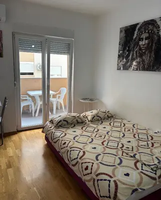 a bedroom with a bed with a picture on the wall at Studio 23 in Podgorica
