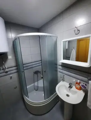 a bathroom with a shower and a sink and a mirror at Studio 23 in Podgorica