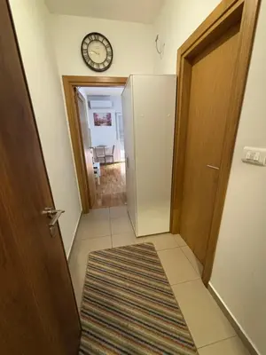 a hallway with a refrigerator and a clock on the wall at Studio 23 in Podgorica