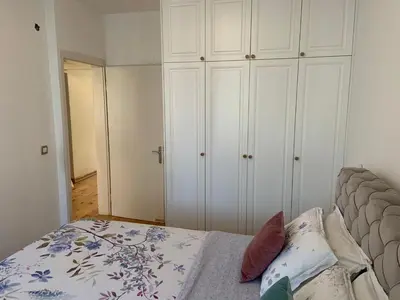 a bedroom with a bed and some white cabinets at Alex Apartments in Budva