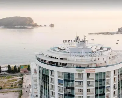 a large building next to a body of water at Luxury 3 bedroom private apt in beachfront Hotel in Budva