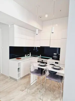 a kitchen with white cabinets and a table and chairs at Luxury 3 bedroom private apt in beachfront Hotel in Budva