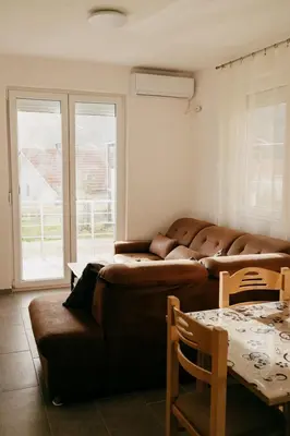 a living room with a brown couch and a table at Deutsche Willa in Sutomore
