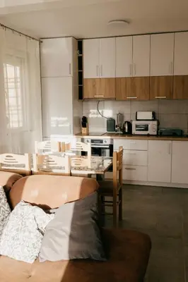 a kitchen with a couch and a table in a room at Deutsche Willa in Sutomore