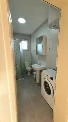 a bathroom with a washing machine and a sink at Deutsche Willa in Sutomore