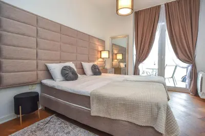 a bedroom with a large bed with a large headboard at Prometheus Apartments in Budva