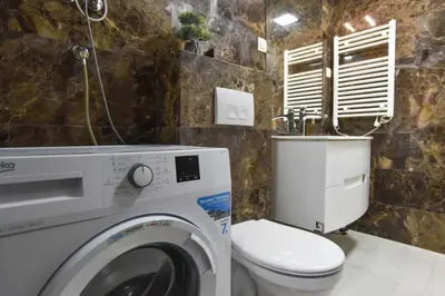 a bathroom with a washing machine and a toilet at Prometheus Apartments in Budva