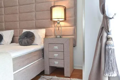 a bed with a nightstand with a lamp on it at Prometheus Apartments in Budva