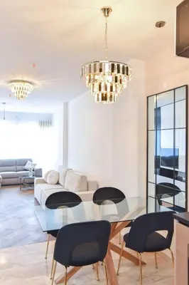 a living room with a glass table and black chairs at Prometheus Apartments in Budva