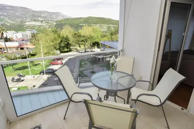 a balcony with a table and chairs and a view of a street at Prometheus Apartments in Budva