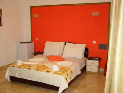 a bedroom with a large bed with an orange headboard at Hotel Wellness & Spa Angelo Gabriel in Buljarica
