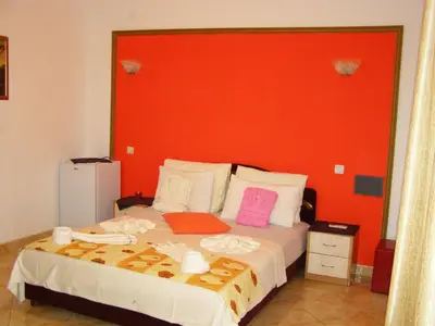 a bedroom with a large bed with a red headboard at Hotel Wellness & Spa Angelo Gabriel in Buljarica