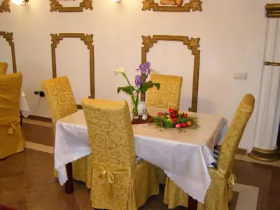 a table with yellow chairs and a vase of flowers on it at Hotel Wellness & Spa Angelo Gabriel in Buljarica