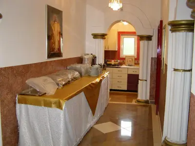 a kitchen with a table in a room with columns at Hotel Wellness & Spa Angelo Gabriel in Buljarica