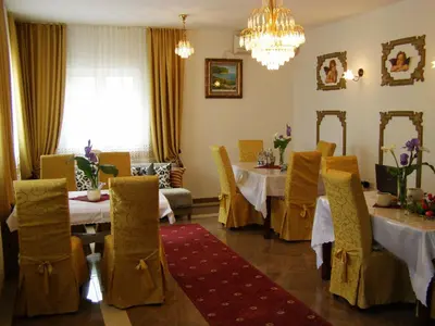 a dining room with tables and chairs and a chandelier at Hotel Wellness & Spa Angelo Gabriel in Buljarica
