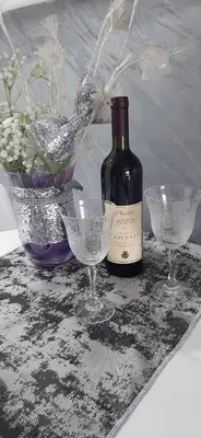a bottle of wine and two glasses on a table at Cozzy apartment near the Aiport Podgorica in Podgorica