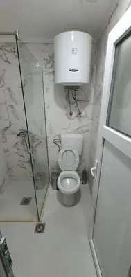 a bathroom with a toilet and a glass shower at Cozzy apartment near the Aiport Podgorica in Podgorica