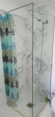 a bathroom with a shower with a glass door at Cozzy apartment near the Aiport Podgorica in Podgorica