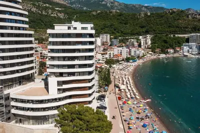a view of a beach with a building and a city at Montenegro at the Green Stone beach in Budva