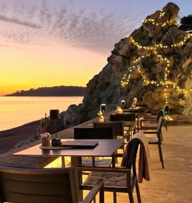 a group of tables with lights on a beach at Montenegro at the Green Stone beach in Budva