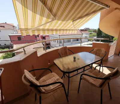 a patio with a table and chairs on a balcony at Apartments Montenegrina in Ulcinj