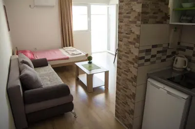 a small living room with a couch and a small kitchen at Apartments Miki in Bar