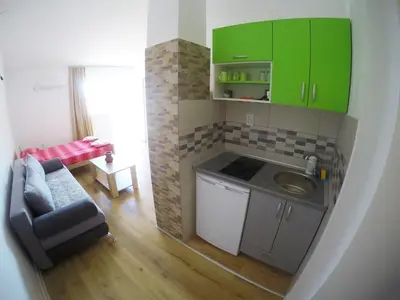 a small kitchen with green cabinets and a sink at Apartments Miki in Bar