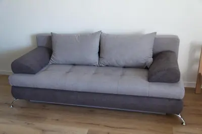 a grey couch in a living room with wooden floors at Apartments Miki in Bar