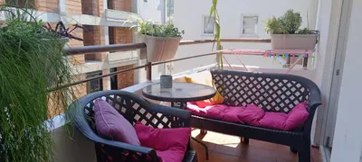 a balcony with two chairs and a table with pillows at Budva apartman Haustor in Budva