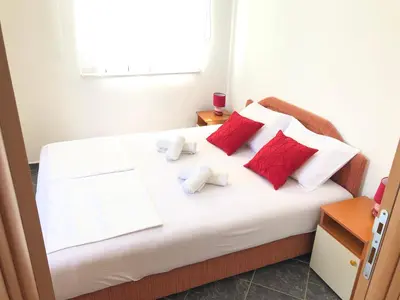 a bedroom with a bed with red and white pillows at Apartments Radosevic in Ulcinj